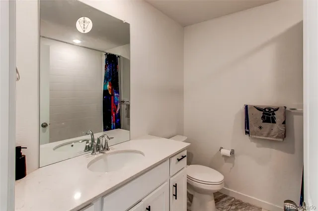 a bathroom with a sink toilet vanity and shower