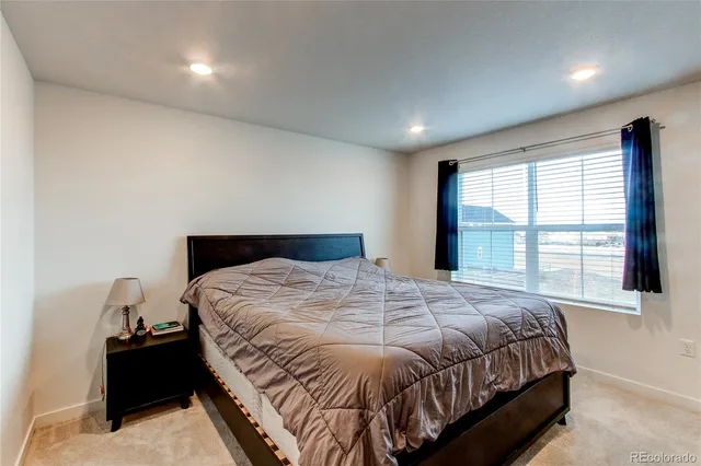 a bedroom with a bed and a large window