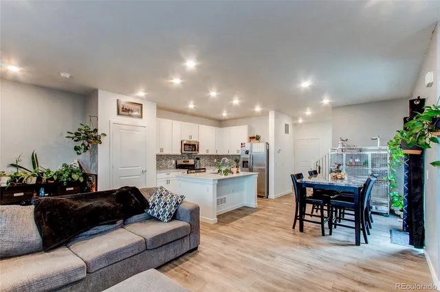 a living room with furniture a dining table and kitchen view