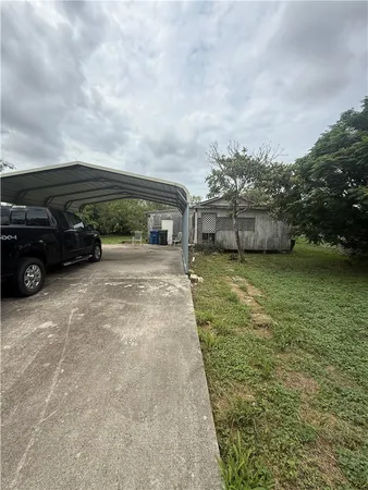 a view of a house with yard and car parked