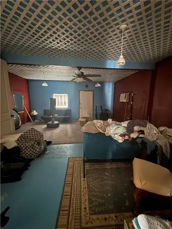 a living room with a couch a rug kitchen view and a fireplace