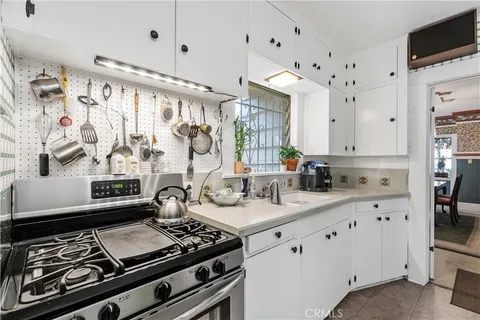 a kitchen with stainless steel appliances a stove and white cabinets