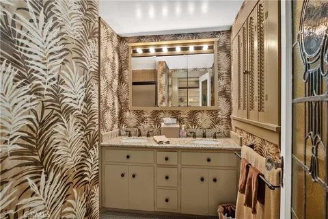 a bathroom with a granite countertop sink a mirror and shower