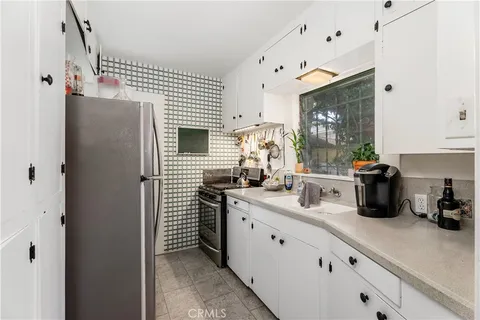a kitchen with stainless steel appliances a sink stove and cabinets