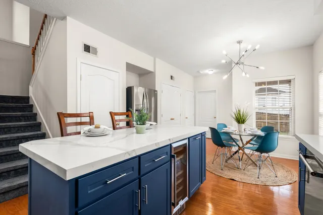 a living room with furniture a dining table and a potted plant