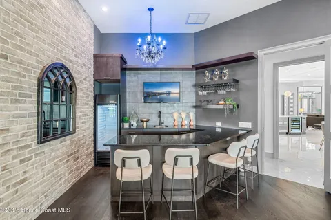 a dining room with furniture a chandelier and wooden floor