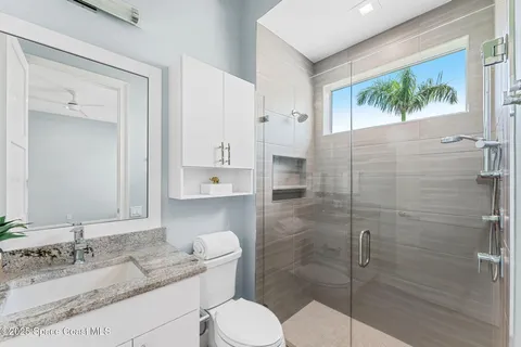 a bathroom with a granite countertop sink toilet and shower