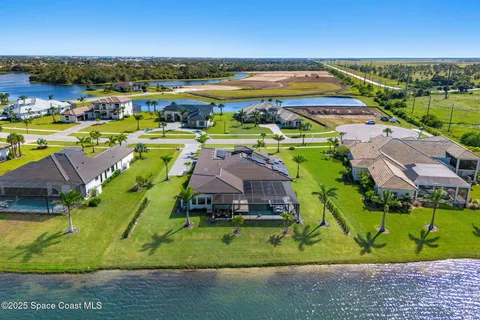 an aerial view of residential houses with outdoor space and lake view