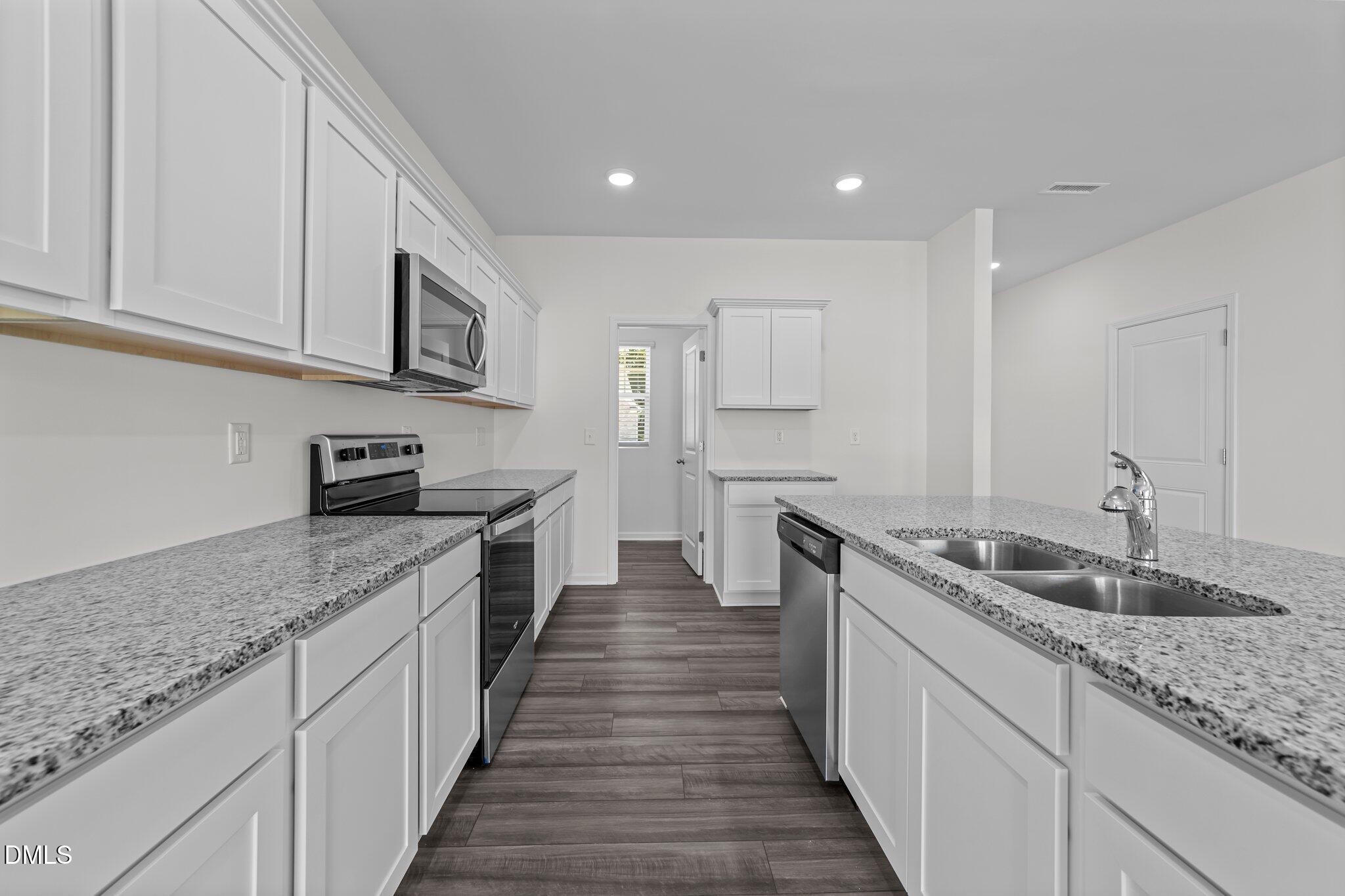 2577 Quarry Road Rolesville, NC 27571 - Photo 15 of 38 a kitchen with stainless steel appliances granite countertop a sink stove and cabinets