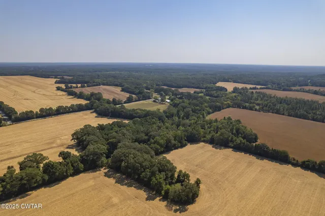 an aerial view of ocean and residential houses with outdoor space