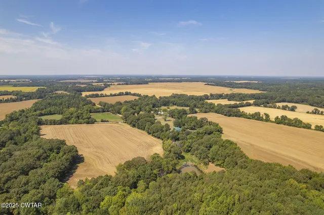 an aerial view of ocean and residential houses with outdoor space