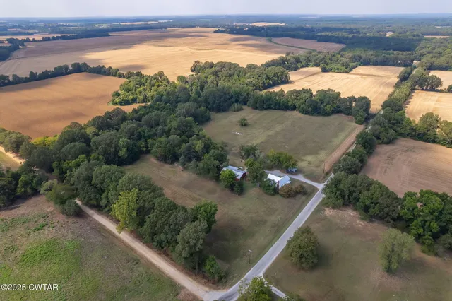 an aerial view of lake residential house with outdoor space and trees around