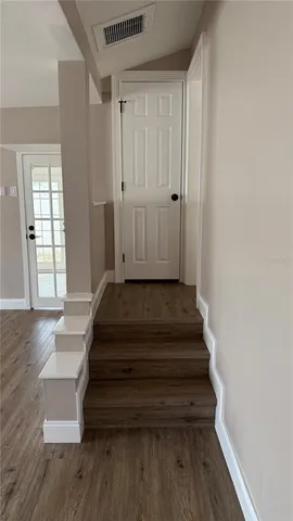 a view of entryway and hall with wooden floor