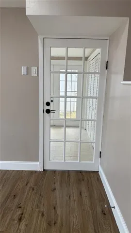 an empty room with wooden floor and sliding door
