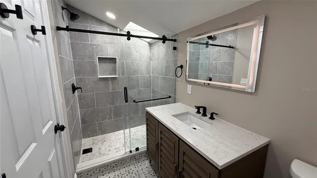 a bathroom with a shower sink and mirror
