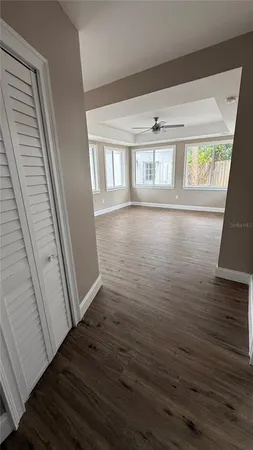 a view of an empty room with wooden floor and a window