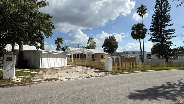 a view of a house with a yard and large tree