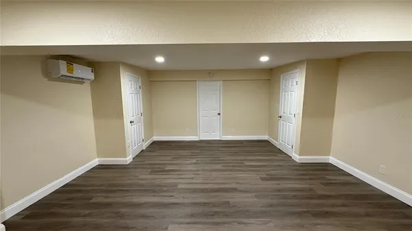 a view of an empty room with wooden floor