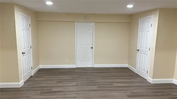 a view of kitchen with stainless steel appliances wooden floor and large window