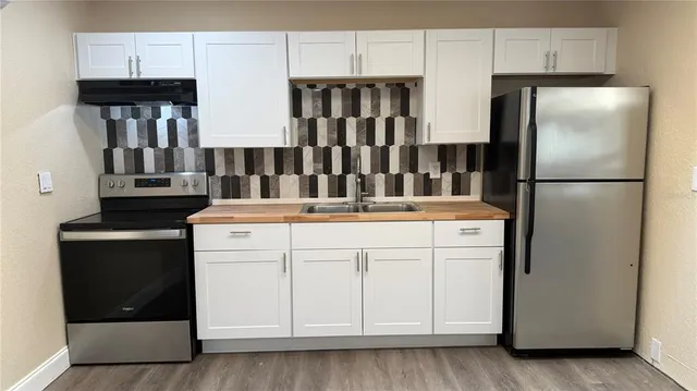 a kitchen with stainless steel appliances a refrigerator sink and microwave