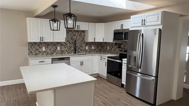 a kitchen with stainless steel appliances a sink and a refrigerator
