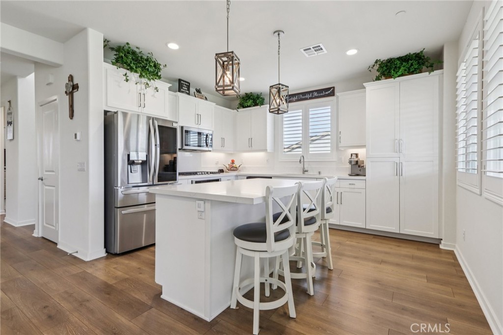 35293 Funk Way Beaumont, CA 92223 - Photo 11 of 70 a kitchen with stainless steel appliances granite countertop a table chairs refrigerator and microwave