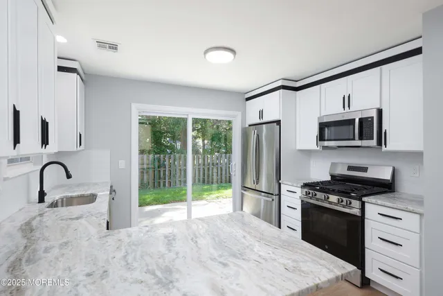a kitchen with granite countertop a stove and a refrigerator