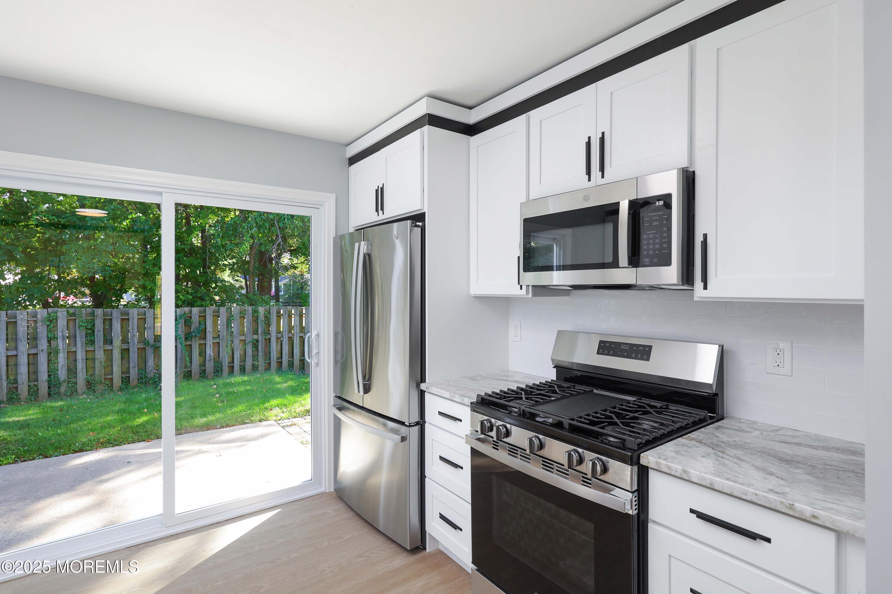 4 Ellison Court Union Beach, NJ 07735 - Photo 12 of 35 a kitchen with stainless steel appliances granite countertop a stove a refrigerator and a microwave