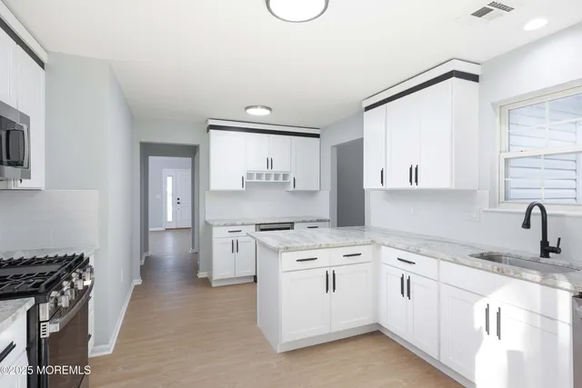 a kitchen with white cabinets and appliances