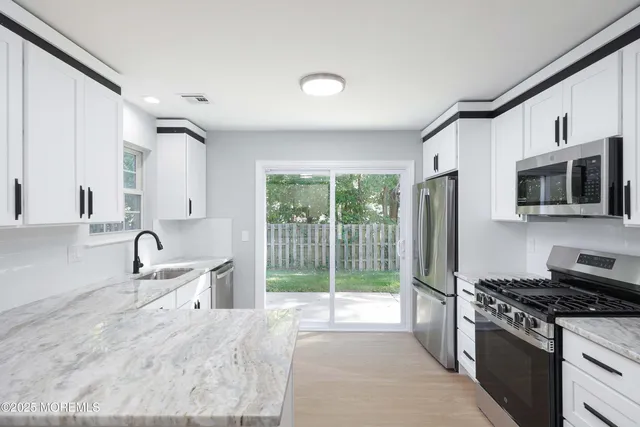 a kitchen with granite countertop a sink and a stove top oven