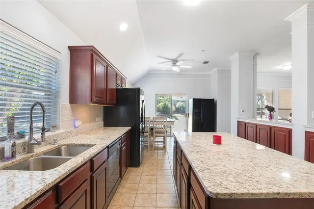 a large kitchen with granite countertop a sink stainless steel appliances and counter space