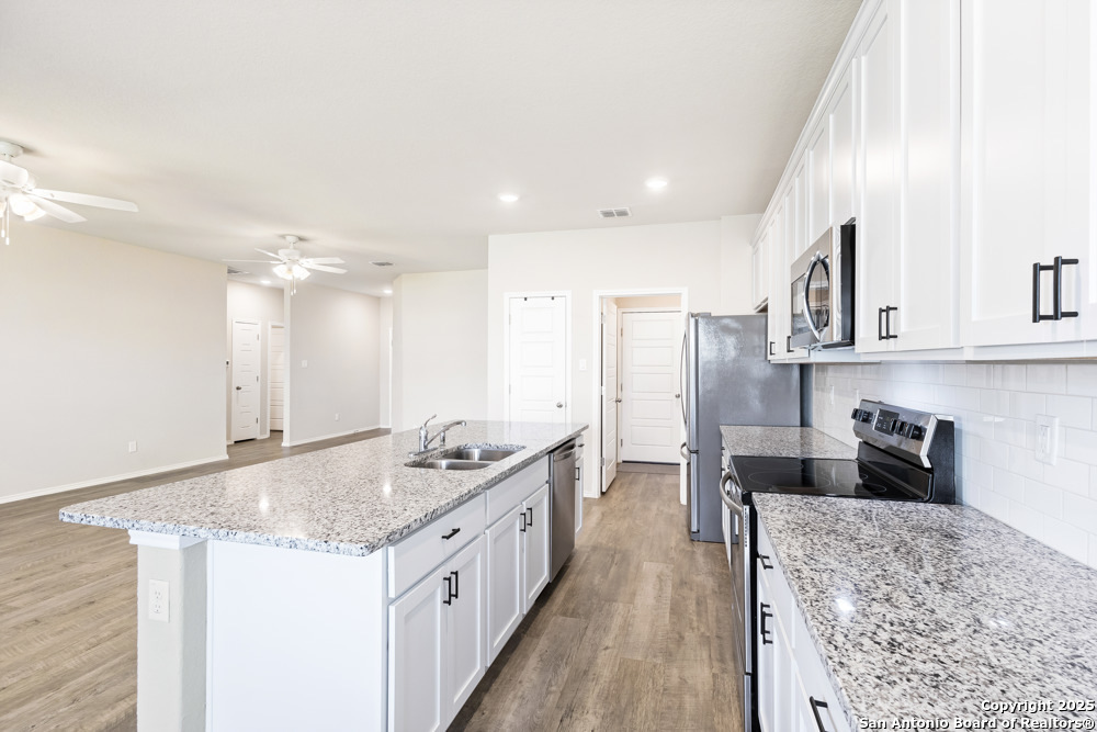 19916 Doc Holiday Drive Lytle, TX 78052 - Photo 10 of 27 a kitchen with stainless steel appliances granite countertop a sink stove and refrigerator