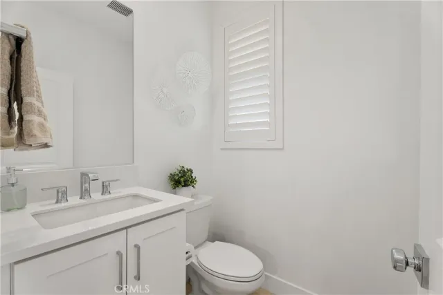 a bathroom with a toilet sink vanity and mirror
