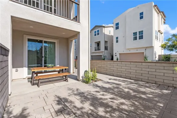 a backyard of a house with barbeque oven table and chairs