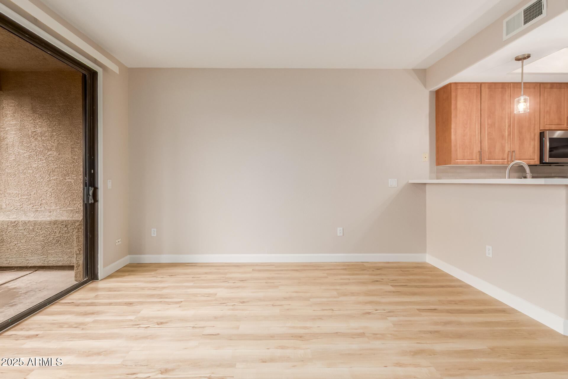 705 West Queen Creek Road, Unit 1208 Chandler, AZ 85248 - Photo 6 of 39 a view of kitchen and empty room with wooden floor