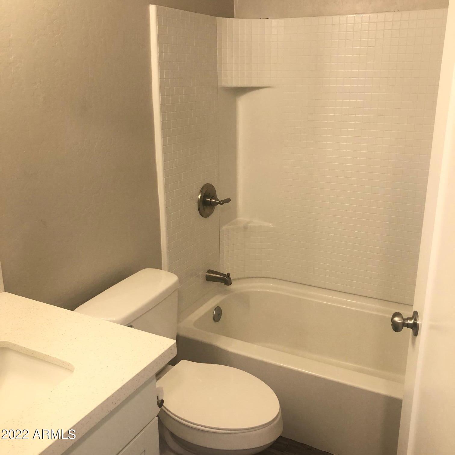 2246 West Southern Avenue, Unit 17 Phoenix, AZ 85041 - Photo 6 of 7 a bathroom with a toilet and a bath tub