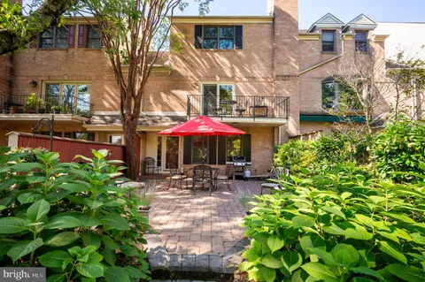 a patio with table and chairs under an umbrella