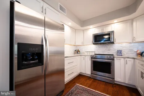 a kitchen with stainless steel appliances granite countertop a refrigerator a stove top oven a sink and dishwasher