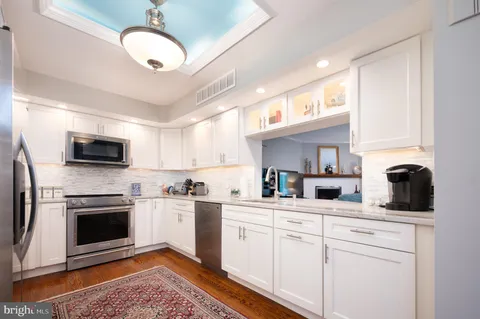 a kitchen with stainless steel appliances granite countertop a stove a sink and a microwave