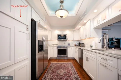 a large kitchen with stainless steel appliances granite countertop a stove and cabinets