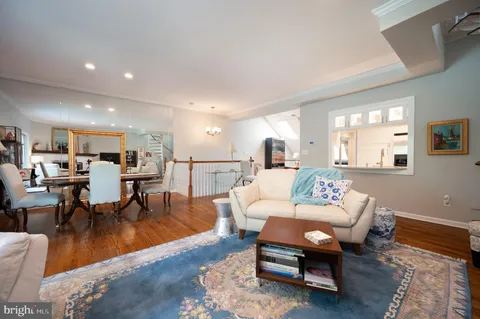 a living room with furniture dining table a lamp and a window