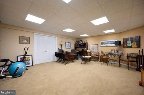 a living room with furniture and a gym machine