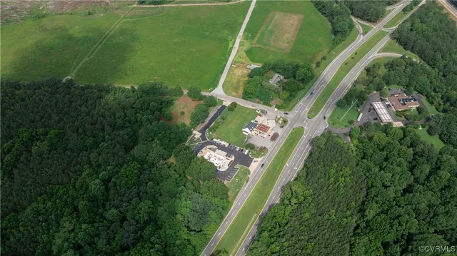 an aerial view of residential houses with outdoor space and trees