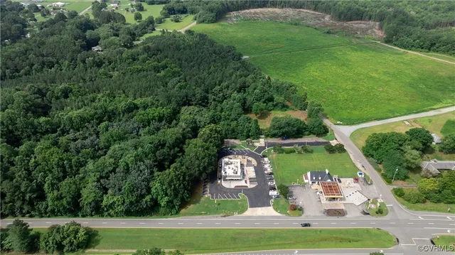 an aerial view of residential houses with outdoor space and trees