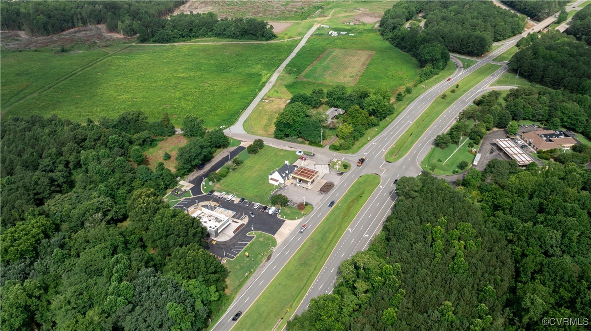 9131 Barhamsville Road Toano, VA 23168 - Photo 16 of 39 an aerial view of green landscape with trees houses and mountain view