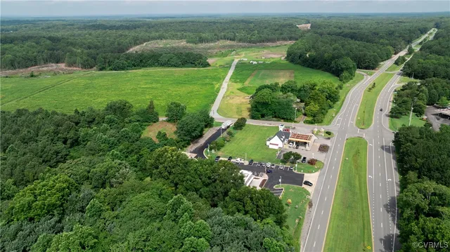 an aerial view of residential houses with outdoor space and trees
