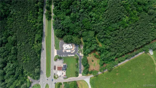 an aerial view of residential houses with outdoor space and trees