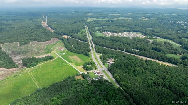 an aerial view of green landscape with trees houses and mountain view
