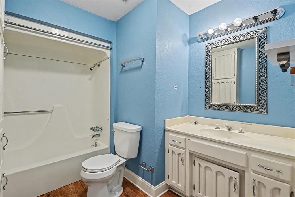 332 Cook Road Willow Park, TX 76087 - Photo 23 of 26 Bathroom featuring a shower/tub combination, single vanity with integrated sink, wood-finish flooring, and a decorative mirror