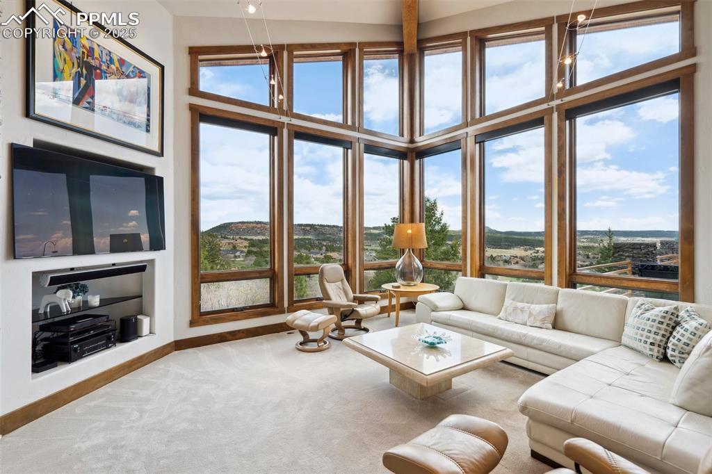 18496 Pixie Park Road Monument, CO 80132 - Photo 9 of 50 a living room with furniture large windows and a fireplace